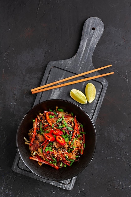 Foto udon noodles con carne di maiale e verdure in salsa piatto nero no people