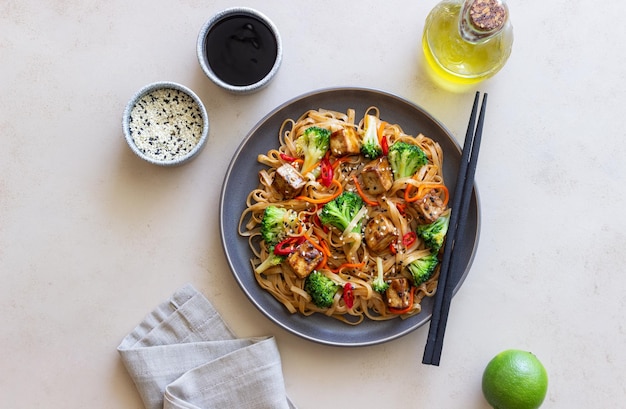 Foto tagliatelle udon con tofu broccoli carote pepe e sesamo alimentazione sana cibo vegetariano cibo asiatico