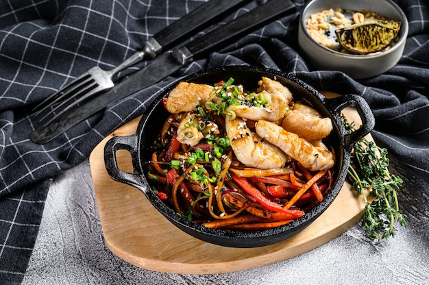 Udon roerbaknoedels met kip en groenten in de pan.