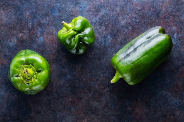 Ugly bell pepper on dark background. Deformed homegrown green bell pepper. Top view