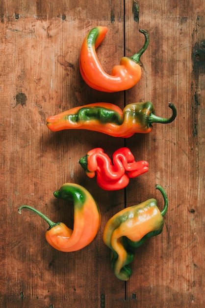 Ugly bell pepper on wooden background Concept of zero waste production Top view Copy space Non gmo vegetables