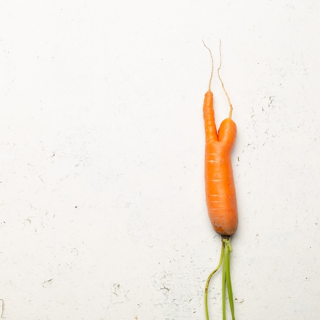 Ugly carrots on a white background. Ugly food concept, top view.