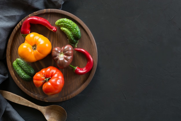 Ugly colorful tomato, pepper, cucumber on black, 