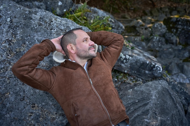 ugly man relaxing on the stones