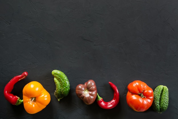 못생긴 유기 다채로운 토마토, 고추, 오이 검정에.