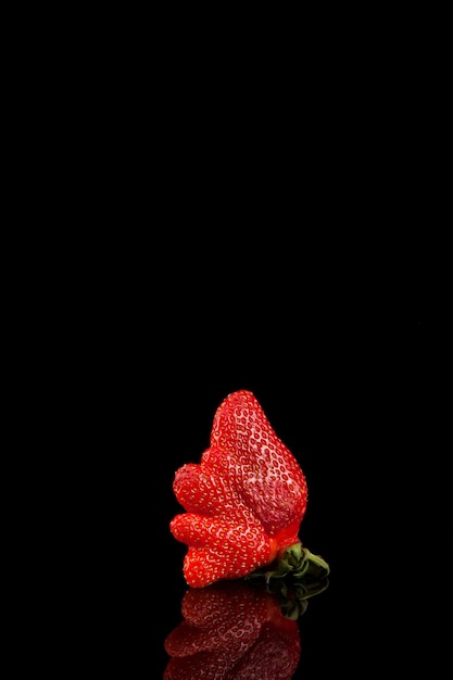 Foto fragola coltivata in casa organica brutta con lo spazio della copia. cibo brutto alla moda. strano frutto imperfetto divertente. prodotti deformi, concetto di spreco alimentare.