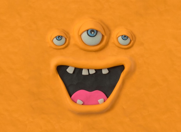 Uglyeyed monster schepsel met de hand gemaakt van oranje plasticine Lelijk monster gezicht emotionele expressie
