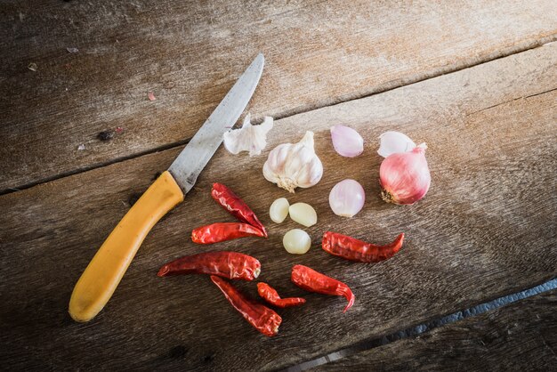 Uien, knoflook en droge chili op houten tafel