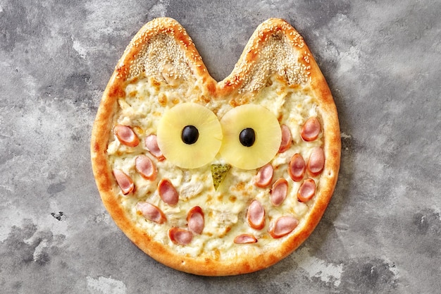 Uilvormige kinderpizza met roomkaassaus kip Weense worst ananas olijven ingelegde komkommer en sesam