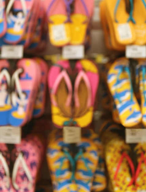 Uit focus van levendige kleuren strandsandalen die in de winkel hangen