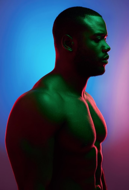 Uitdagingen maken je alleen maar sterker Studio-opname van een man die shirtless poseert tegen een neonachtergrond