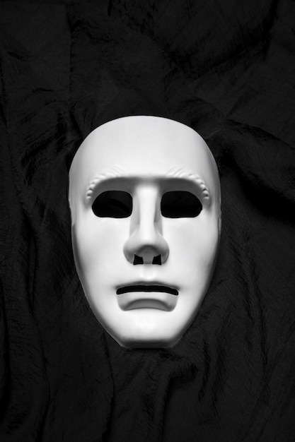 Foto uitdrukkingsloze witte maskers op een zwarte doek