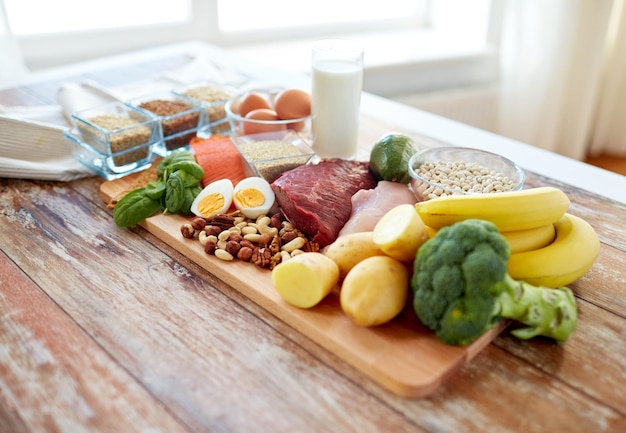 uitgebalanceerd dieet, koken, culinair en voedselconcept - close-up van groenten, fruit en vlees op houten tafel