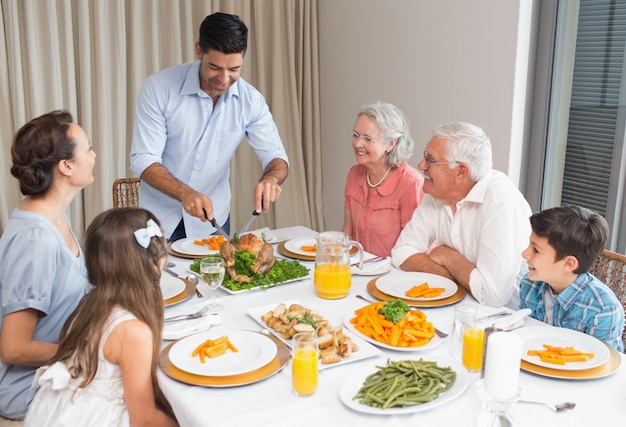 Uitgebreide familie aan eettafel in huis