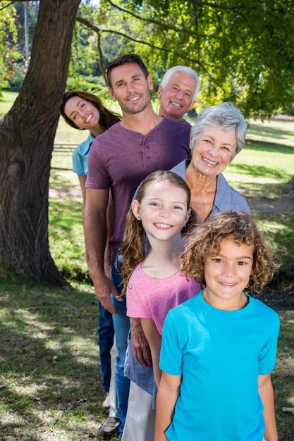 Uitgebreide familie die in het park glimlacht