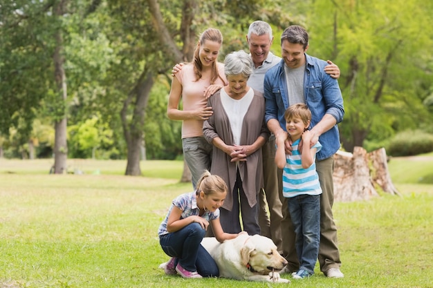 Uitgebreide familie met hun huisdierenhond bij park