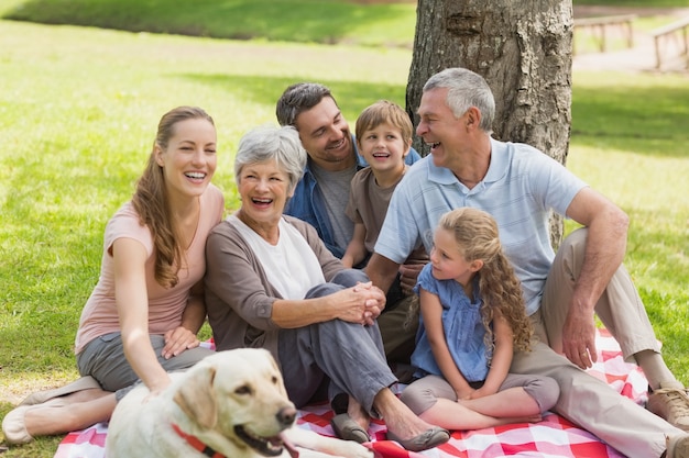 Uitgebreide familie met hun huisdierenhond bij park