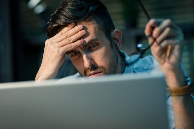 Uitgeput werknemer met behulp van laptop