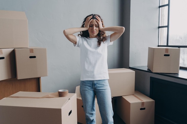 Uitgeputte vrouw is moe van het inpakken van kartonnen dozen met ducttape Angst en stress