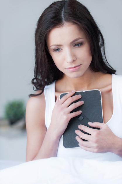 Uitmaken. Depressieve jonge vrouwen die een fotolijst vasthouden en huilen