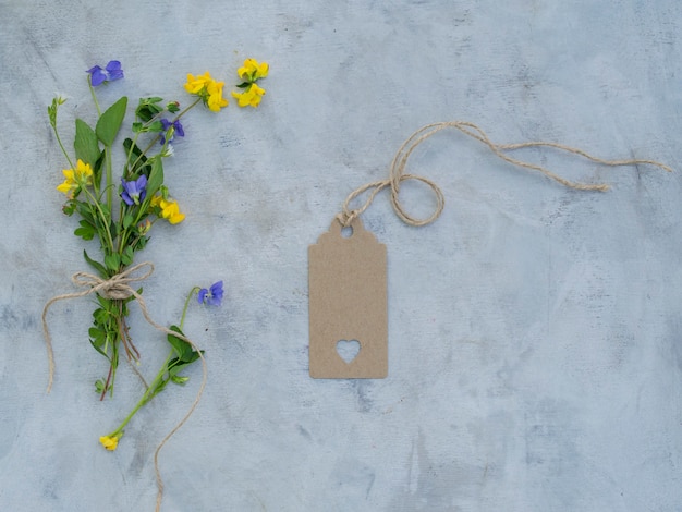 Uitstekend model met de zomerbloemen, een leeg etiket op grijze achtergrond.