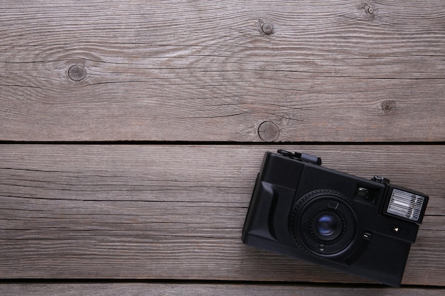 Uitstekende camera op grijze houten achtergrond.