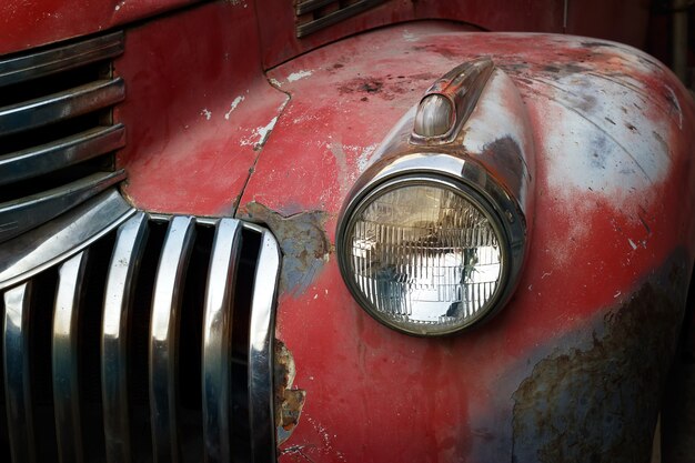 Foto uitstekende roestige rode vrachtwagenauto met een nieuwe koplamp