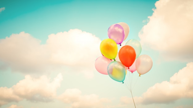 Uitstekende veelkleurige ballons met gedaan met een retro effect van de instagramfilter op blauwe hemel. Ideeën voor de achtergrond van liefde in de zomer en valentijnskaart, huwelijks wittebroodswekenconcept.