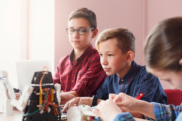 Uitvindingen en creativiteit voor kinderen. Geconcentreerde schoolkinderen die robots bouwen bij wetenschapsklasse. Vroege ontwikkeling, doe-het-zelf, innovatie, geïntegreerd onderwijs, modern technologieconcept