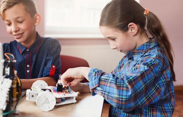 Uitvindingen en creativiteit voor kinderen. Opgetogen kinderen die robots bouwen bij wetenschapsklasse. Vroege ontwikkeling, doe-het-zelf, innovatie, geïntegreerd onderwijs, modern technologieconcept