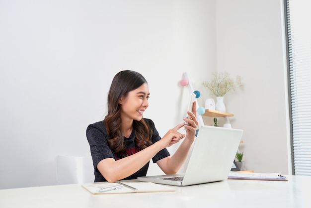 Uitvoerende financiële aziatische vrouw die aan een bureau zit en aan laptop werkt