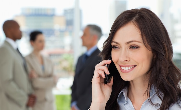 Uitvoerende vrouw die op de celtelefoon spreekt