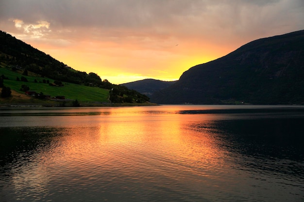 Uitzicht op bergen en meer bij zonsondergang