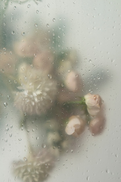 Uitzicht op bloemen achter condensglas