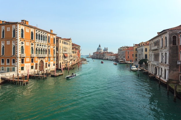 Uitzicht op Canal Grande. Verschillende boten drijven langs een fraai architectonisch complex van dijken