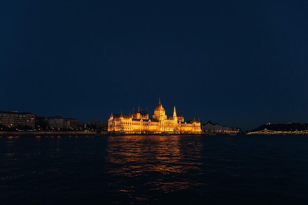 Uitzicht op de avondstad aan de oever van de rivier die het parlement verlicht