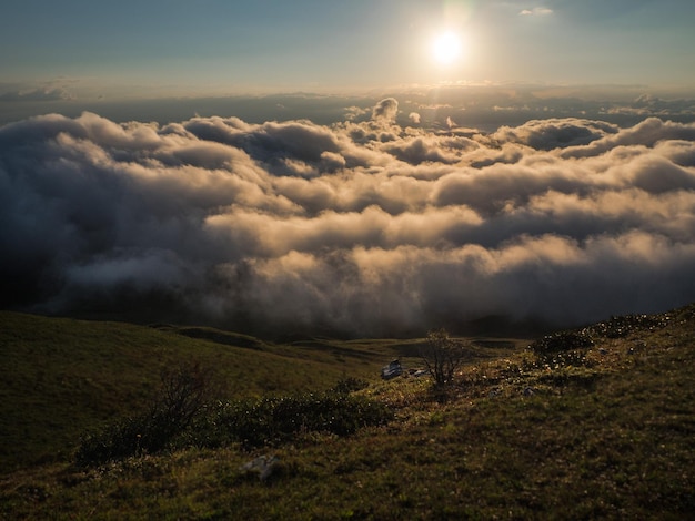 Uitzicht op de bergtop in de zon die boven de wolken uitsteekt