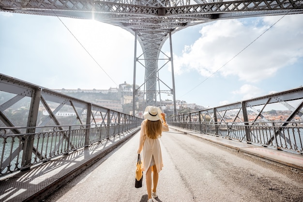 Uitzicht op de beroemde luis-brug met een vrouw die loopt tijdens het mistige en winderige weer in de stad porto, portugal