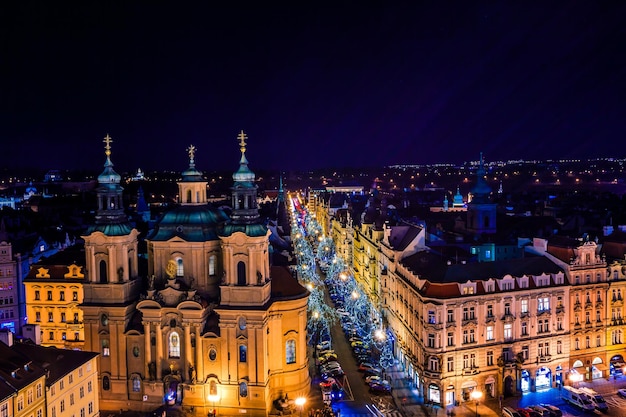 Uitzicht op de daken van Praag met de blauw verlichte torenspitsen in de oude binnenstad van Praag, Tsjechië