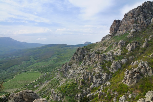 Uitzicht op de enorme rotswanden en de groene vallei bedekt met bos. Prachtig berglandschap