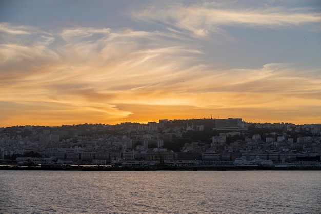 Uitzicht op de haven van algiers bij zonsondergang. rustig weer. uitzicht vanaf schip.