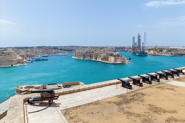 Uitzicht op de haven van Vittoriosa en de batterij van middeleeuwse kanonnen vanaf de muur van Valletta