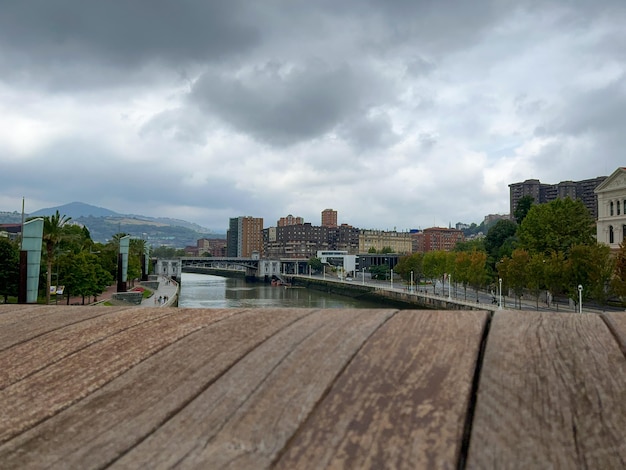 Uitzicht op de immense rivier van Bilbao vanaf de houten brug op een bewolkte dag