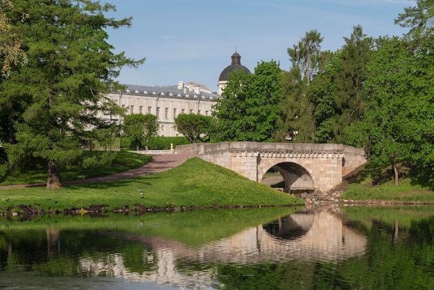 Uitzicht op de Karpin-brug over de cascade tussen de Karpin-vijver en het witte meer van Gatchina-park en het Gatchina-paleis op de achtergrond op een zonnige zomerdag Gatchina Sint-Petersburg, Rusland