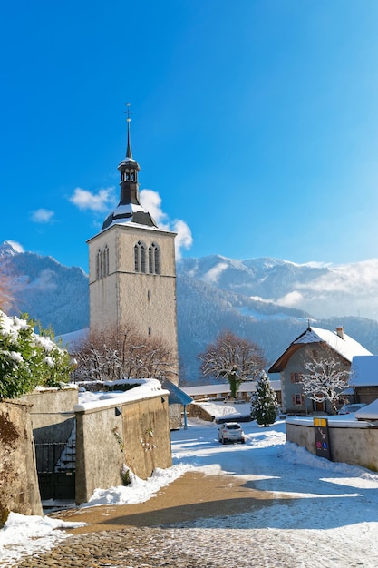 Uitzicht op de kerk in de buurt van het kasteel van Gruyere op een heldere winterdag. Het kasteel, gelegen in het middeleeuwse stadje Gruyeres, Fribourg, is een van de beroemdste in Zwitserland