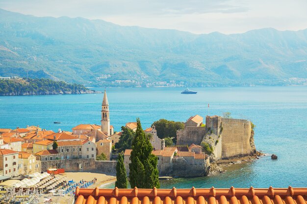 Uitzicht op de kerk van St Ivan, oude muren, bergen en zee in de oude stad Budva, Montenegro