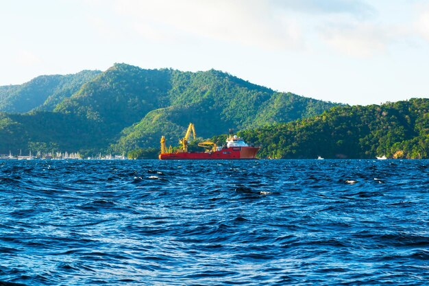 Uitzicht op de kust van Trinidad Island en een offshore bevoorradingsschip dat in de baai voor anker ligt