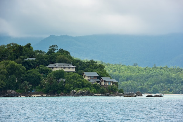 Uitzicht op de kustlijn van de Seychellen met huizen in het bos