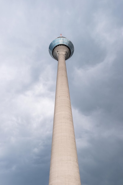 uitzicht op de rijn toren (Rheinturm) met dramatische bewolkte onweersbui hemel in dusseldorf Duitsland. ideaal voor lay-outs van websites en tijdschriften