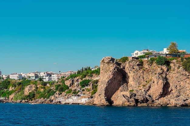 Uitzicht op de rotsachtige kust met hoogbouw in de stad Antalya